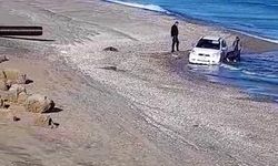 Kumsalda otomobiliyle gezerken, denizde mahsur kaldı  
